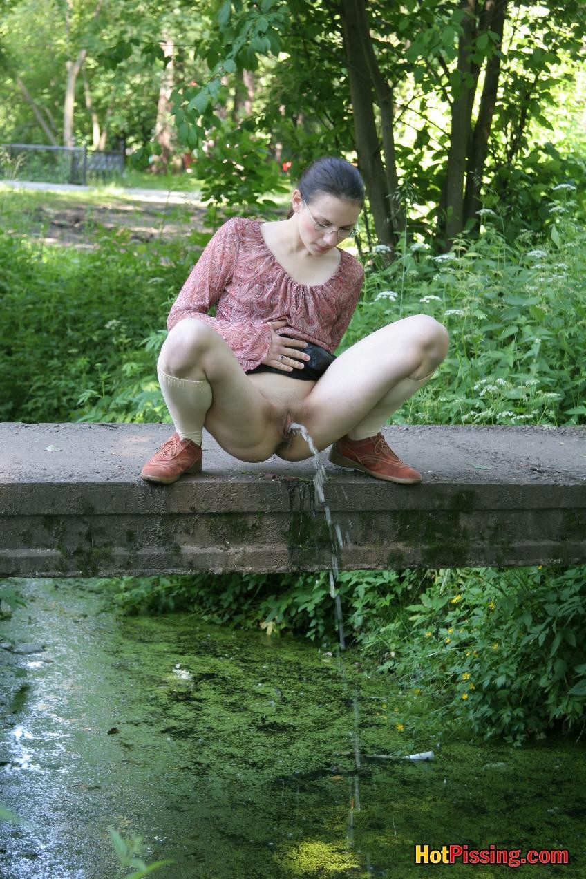 Blushing chick in glasses does a great pee stream from the park bridge #76521309