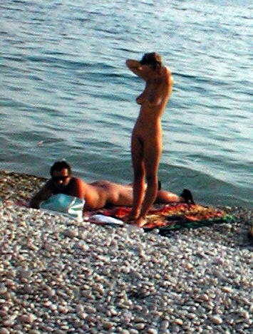 Una diosa desnuda de pechos firmes posa en una playa nudista
 #72254119
