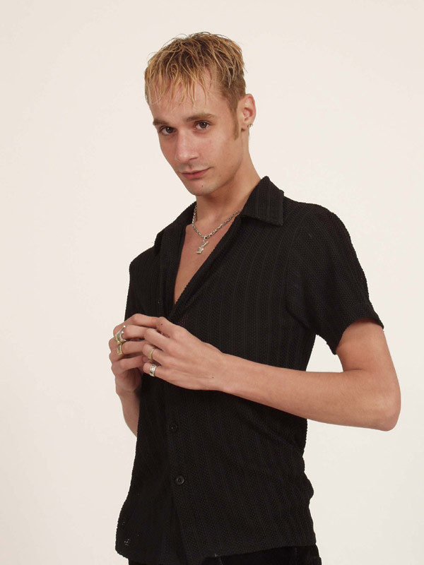 Un jovencito rubio se desabrocha la camisa y muestra algo de piel
 #77003204