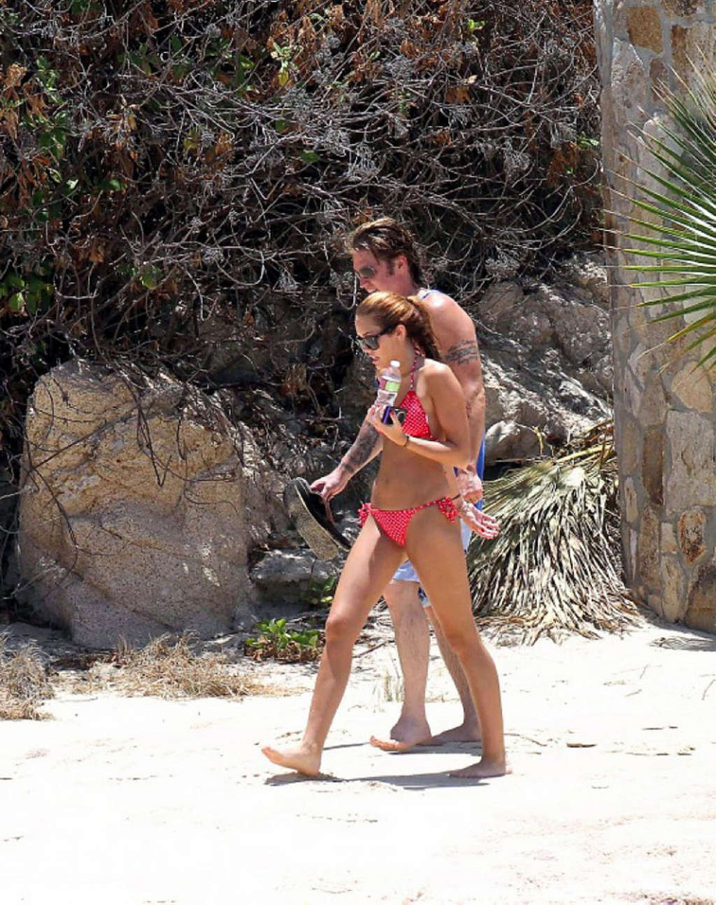 Miley Cyrus, mignonne et sexy en bikini rouge sur la plage, photographiée par les paparazzis.
 #75348150