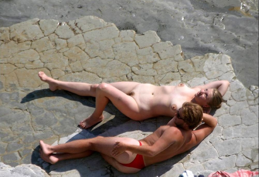 Regardez cette jeune nudiste se frotter le corps avec du sable.
 #72254321