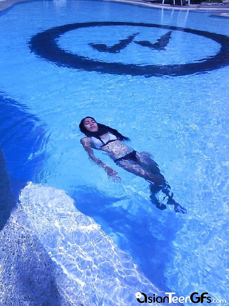 Bella giovane ragazza asiatica che nuota in piscina
 #67249396