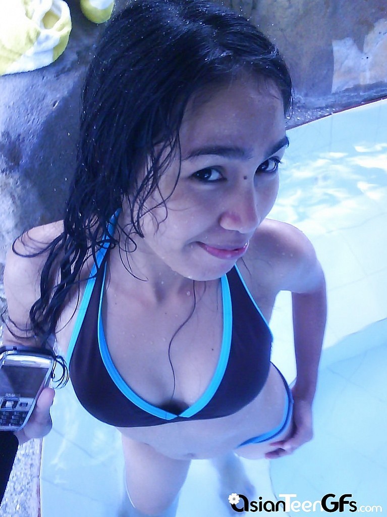 Bella giovane ragazza asiatica che nuota in piscina
 #67249422
