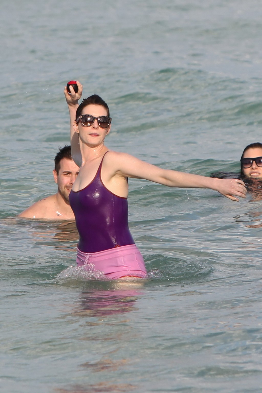 Anne hathaway con traje de baño transparente morado mojado y pantalones cortos en la playa en
 #75200975