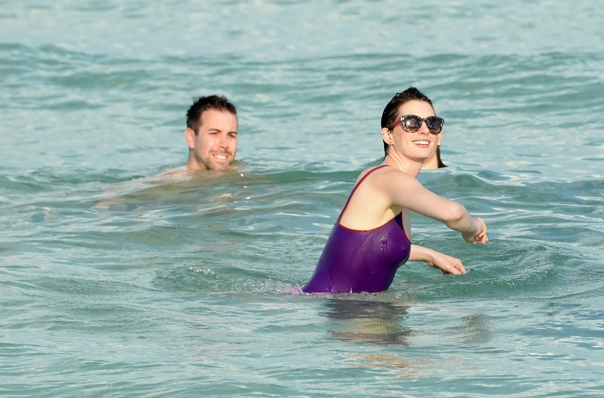 Anne Hathaway wearing wet purple see-through swimsuit and shorts at the beach in #75201002