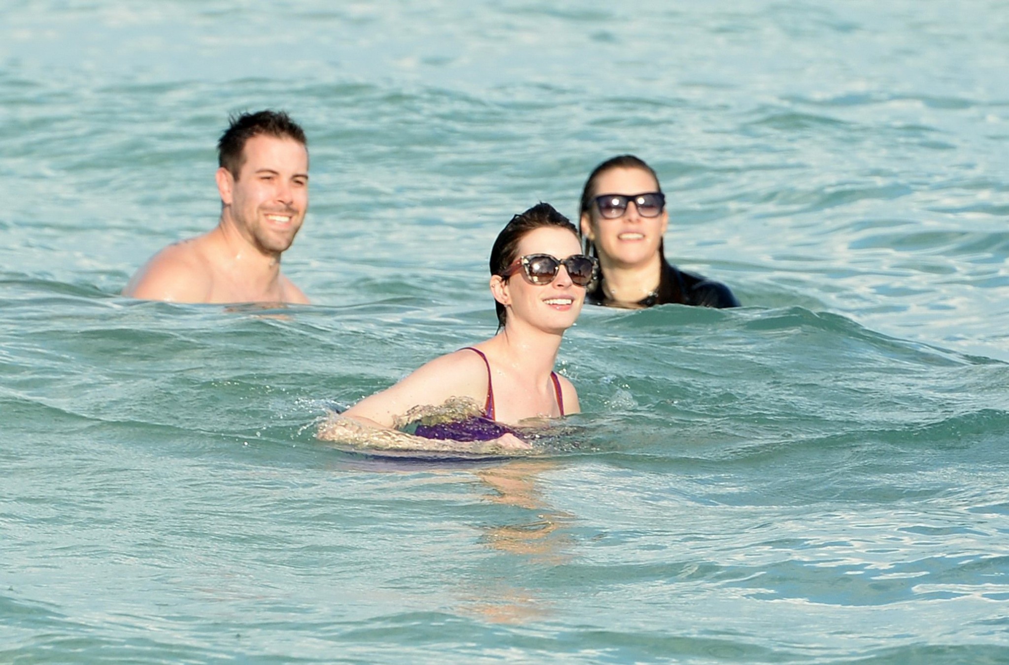 Anne hathaway con traje de baño transparente morado mojado y pantalones cortos en la playa en
 #75201009