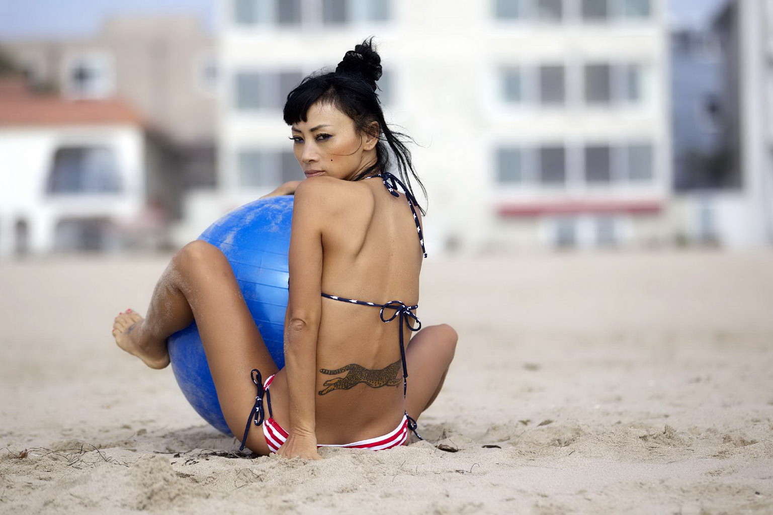 Bai ling con un monokini de rayas estrelladas montando una pelota de pilates en una playa de la
 #75251090