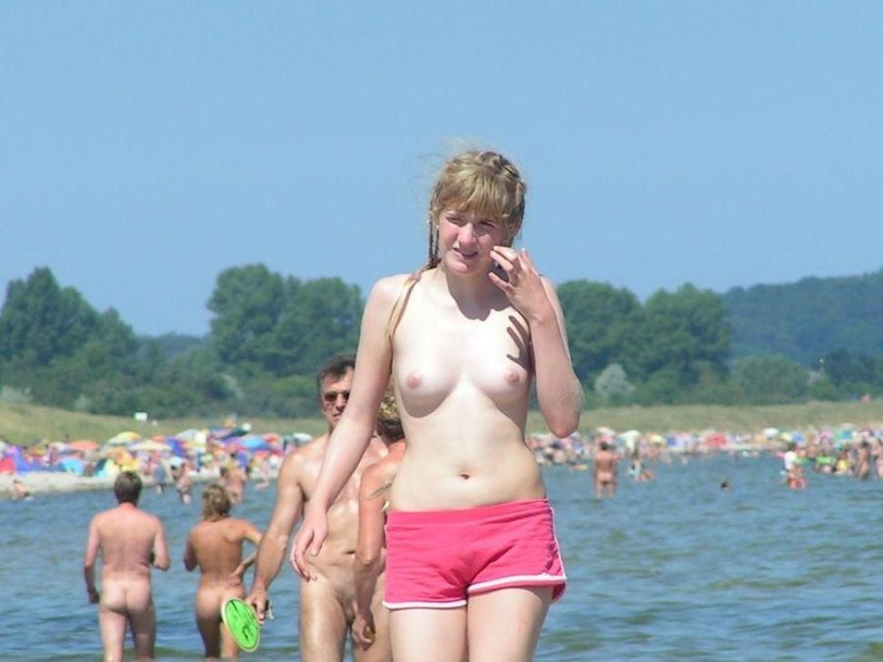 Des ados sexy et nus jouent ensemble sur une plage publique
 #72256950