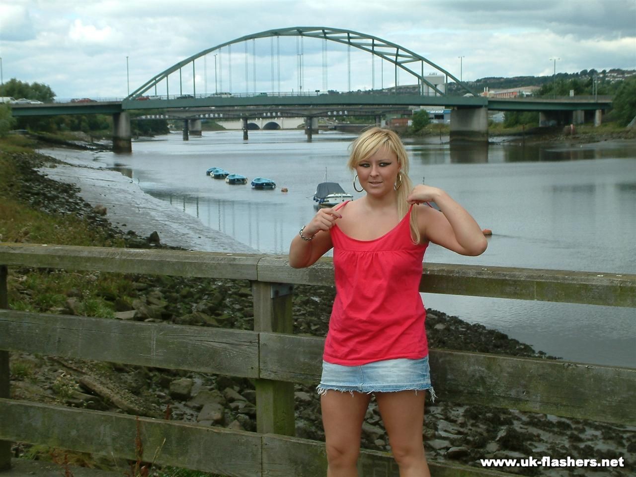 Jeune blonde aux gros seins qui s'exhibe et joue avec sa chatte en public près d'un pont.
 #78889328