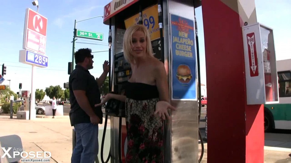Blonde babe, kylie würdig, setzt auf eine sexy necken, während das Pumpen von Gas und zeigt aus 
 #70127866