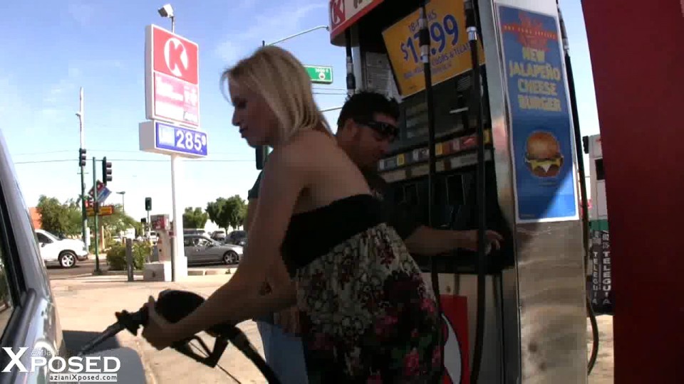 Blonde babe, kylie würdig, setzt auf eine sexy necken, während das Pumpen von Gas und zeigt aus 
 #70127877