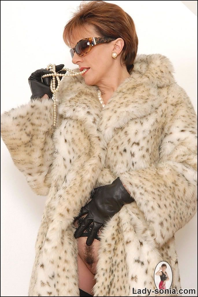 Lady in stockings posing in long fur coat #78028224