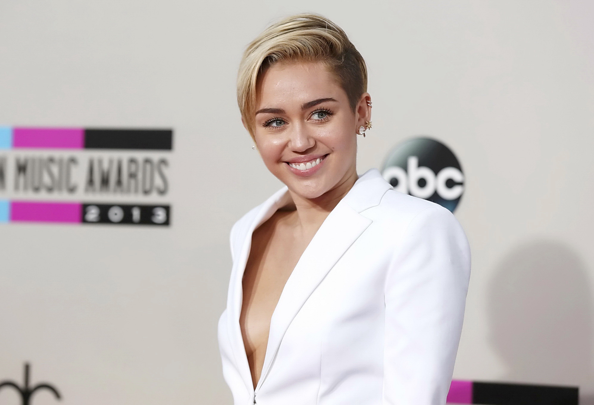 Miley Cyrus braless showing great cleavage in a white suit at 2013 American Musi #75212065