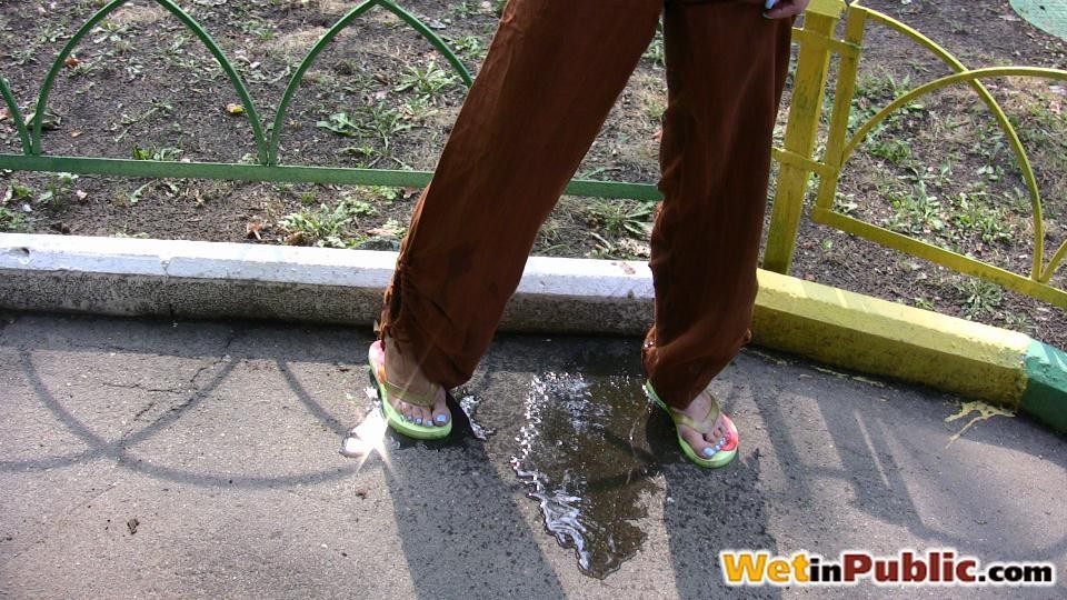 金髪の女性がおねしょをして、歩道に小便の水たまりを残す
 #73240738