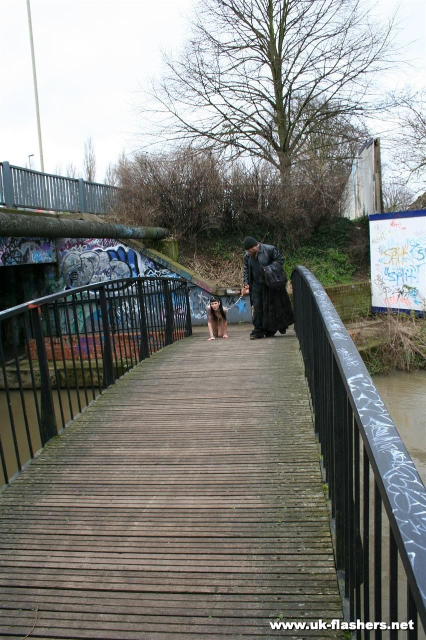 Une jeune femme gothique, épine dans le pied, marche en laisse et s'exhibe nue devant un public. 
 #76544692