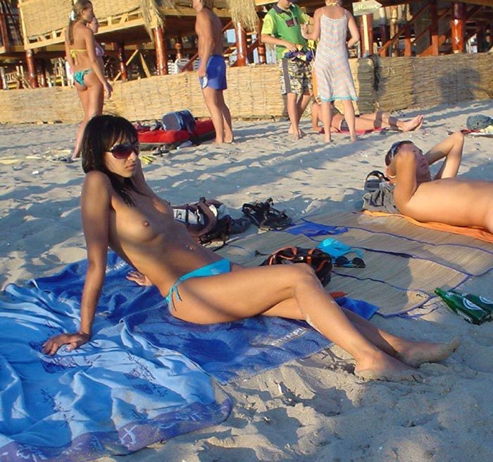 Une jeune nudiste à peine majeure s'allonge nue sur la plage.
 #72252802