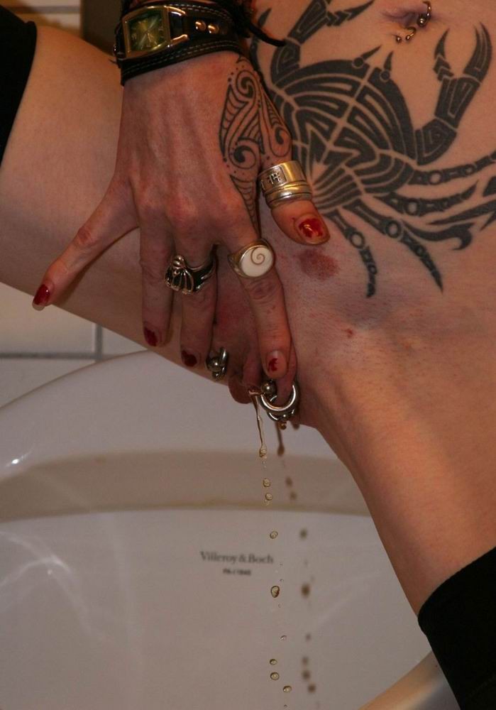 Nenas con piercing y tatuajes extremos orinan en el baño
 #73228548