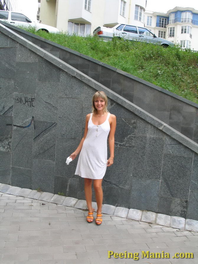 Playful blondie has wonderful time making a piss on the stony pavement #76571456