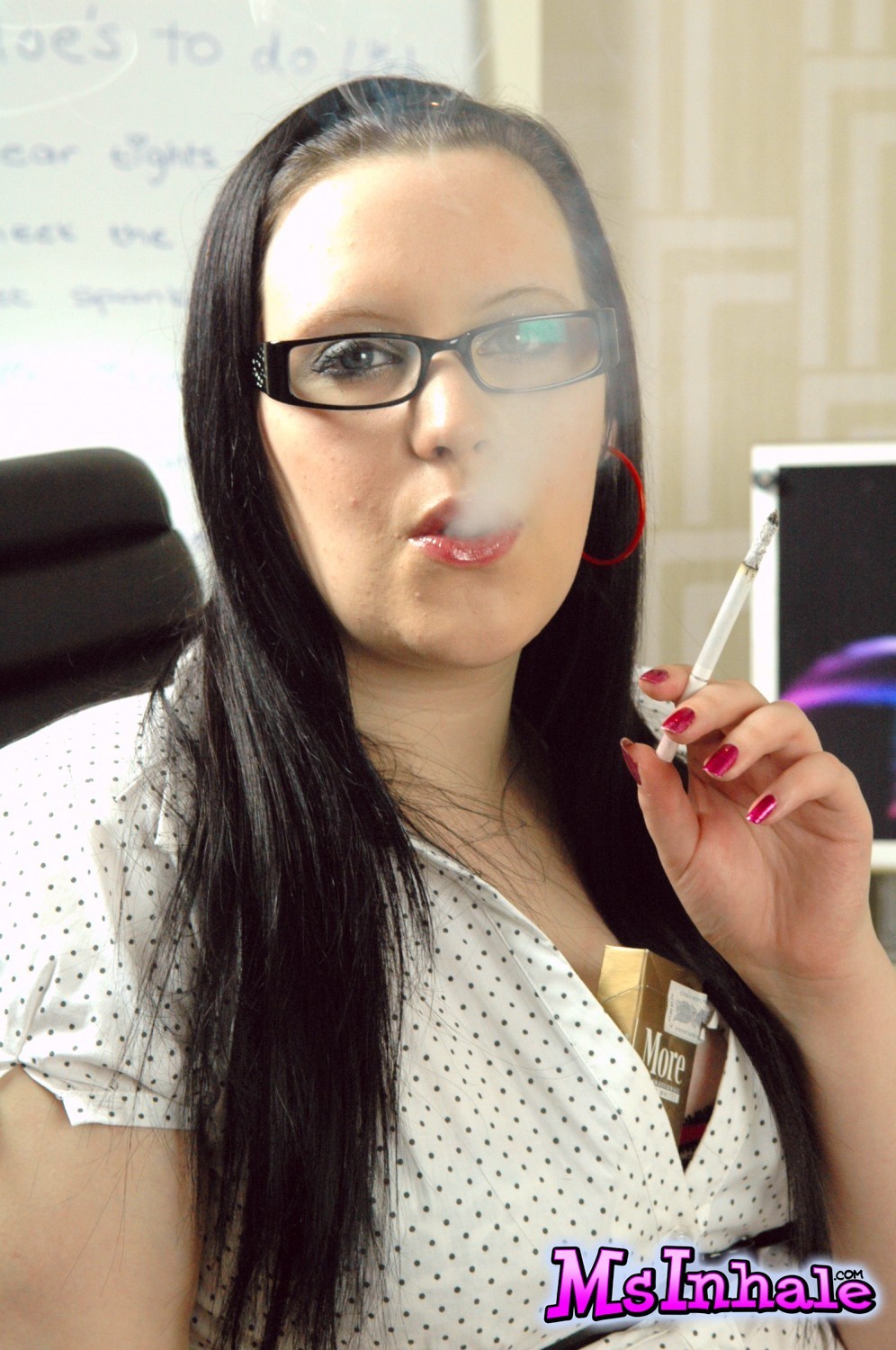 Teen secretary in glasses smoking a More 120 cigarette at work #70269206