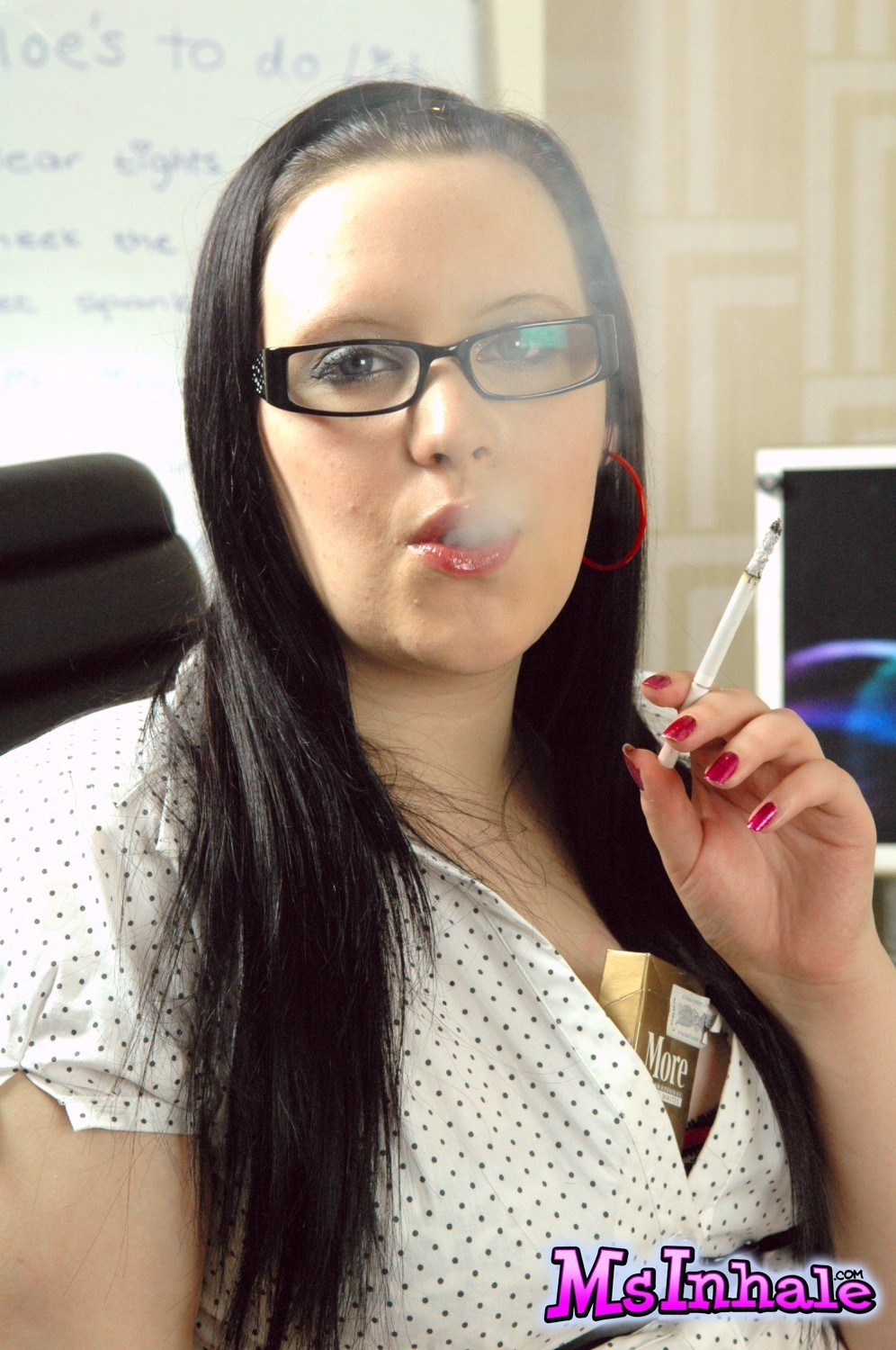 Secretaria joven con gafas fumando un cigarro más 120 en el trabajo
 #70269211