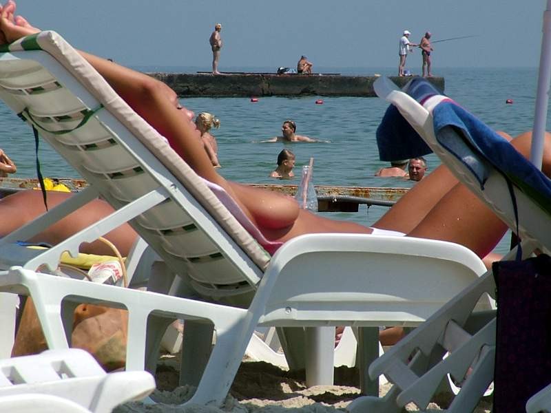 Des amies jeunes nues s'amusent sur une plage publique
 #72252642