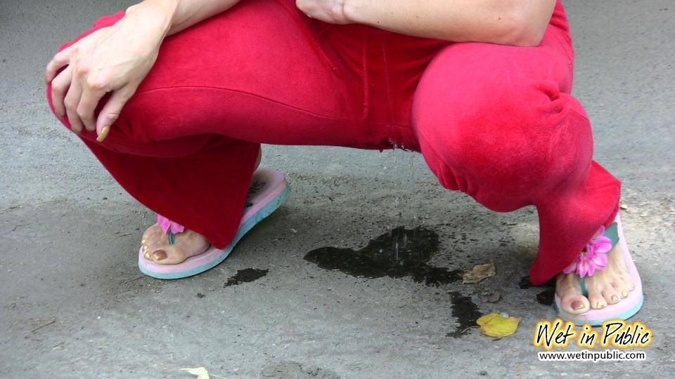 Pulcino amatoriale che bagna i suoi pantaloni rossi e le sue mutandine rosa sulla strada
 #73239122