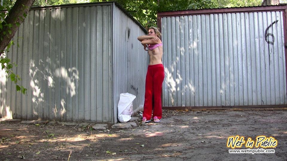 Chica amateur mojando sus pantalones rojos y bragas rosas en la calle
 #73239141
