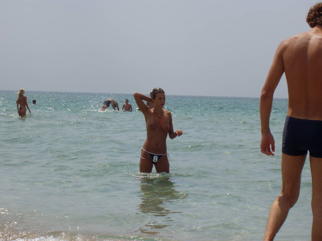 Nudisti abbronzati e fumanti sorpresi nudi in una spiaggia pubblica
 #72247708