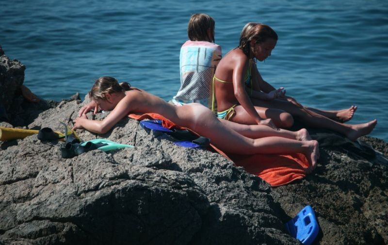 Nudisti abbronzati e fumanti sorpresi nudi in una spiaggia pubblica
 #72247786