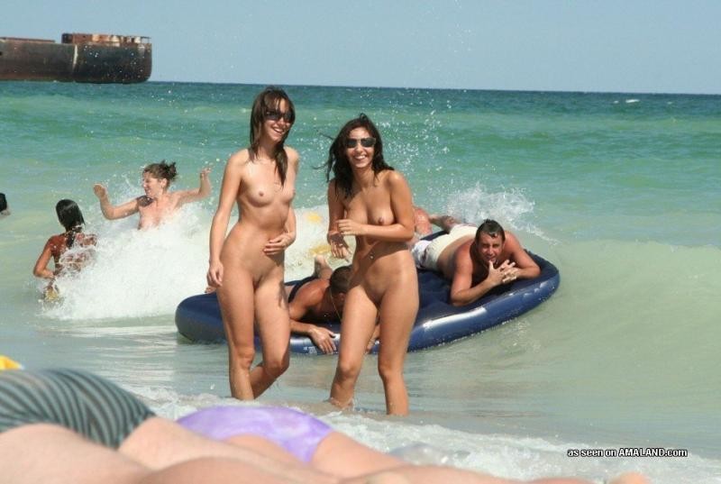 Amiche nude che posano in azione pubblica di nudità sulla spiaggia
 #67392293