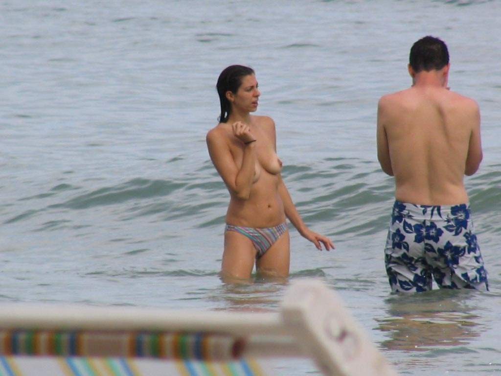 Coppia amatoriale in posa nuda in una spiaggia pubblica
 #72251456