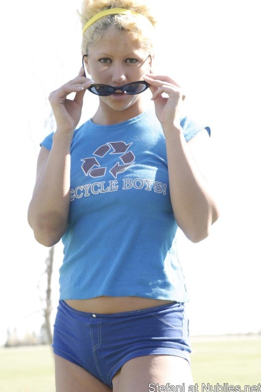 Blondine in ihren winzigen Shorts spielt draußen Blasen
 #74063276