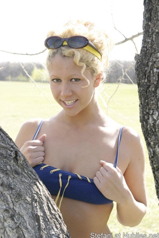 Blondine in ihren winzigen Shorts spielt draußen Blasen
 #74063318