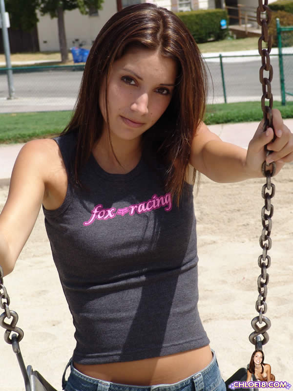Morena joven juega en el patio de recreo
 #75071184