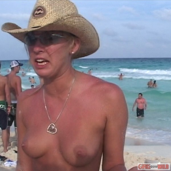 Nena joven en topless en la playa bebiendo una cerveza
 #72321603