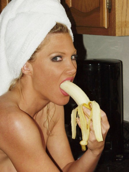 Rubia madura lame un gran plátano
 #74078290