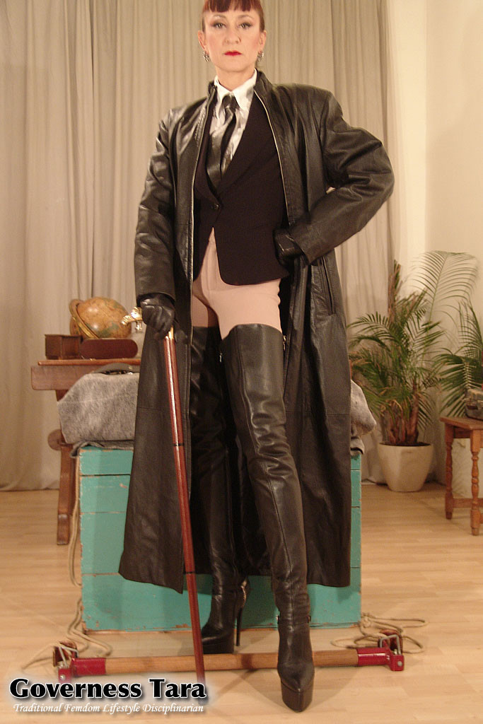 Rigid domina in jodphurs and leather coat and driving boots