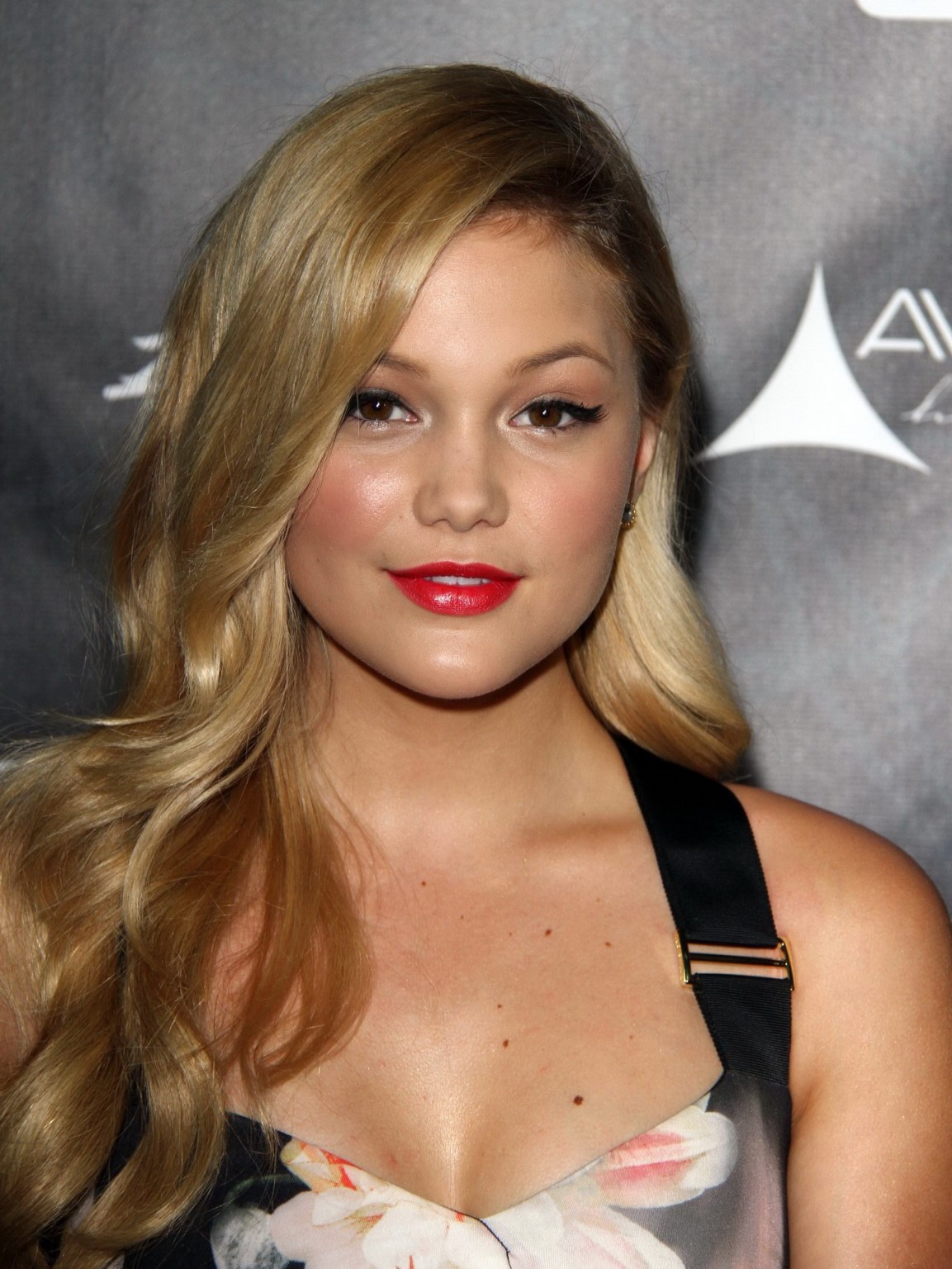 Olivia Holt che mostra la grande scissione in un vestito floreale stretto per il ballo dell'industria 
 #75186136