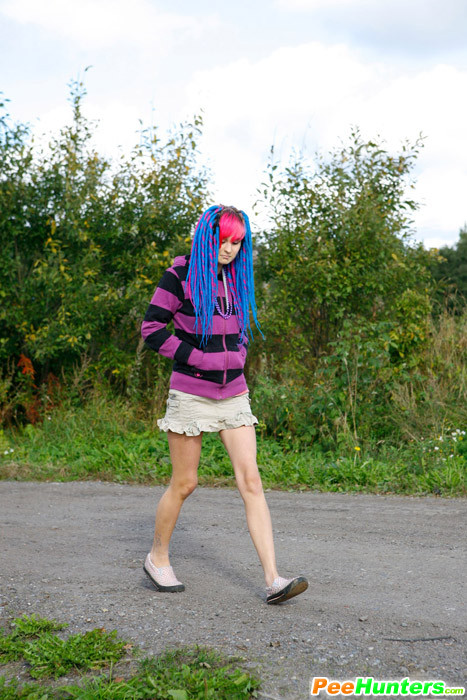 Joven traviesa con pelo rosa y azul pillada orinando
 #78690495