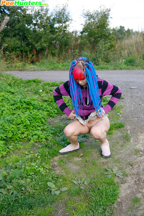 Joven traviesa con pelo rosa y azul pillada orinando
 #78690521