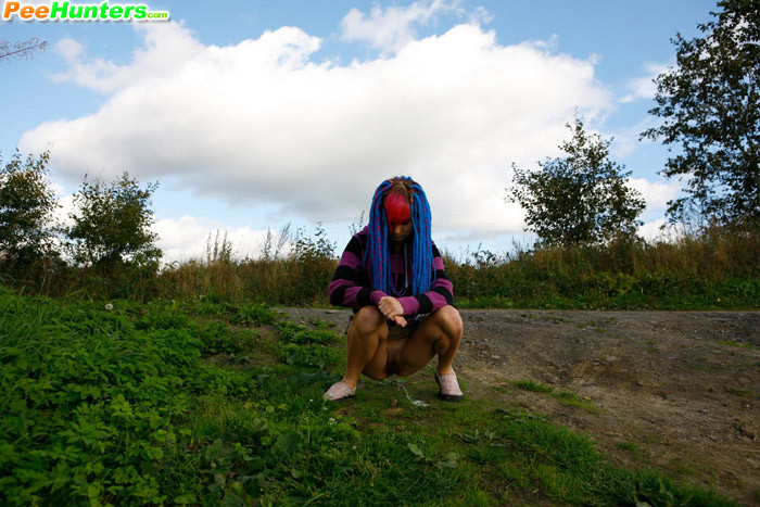 Joven traviesa con pelo rosa y azul pillada orinando
 #78690542