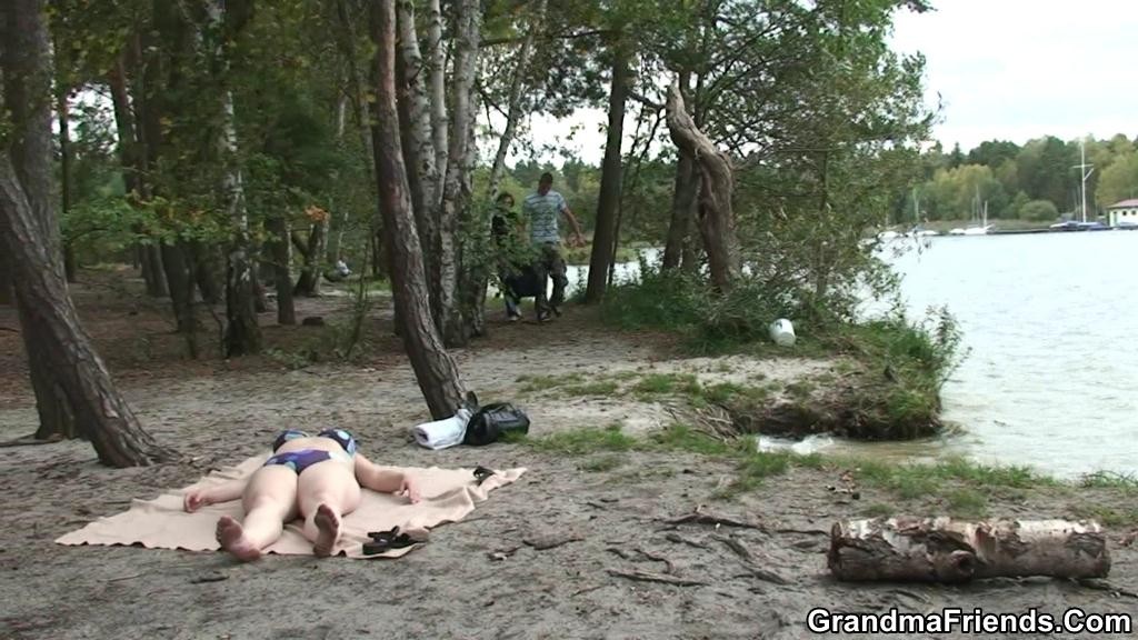 I giovani uomini si imbattono in una nonna in bikini in riva al lago
 #74466646