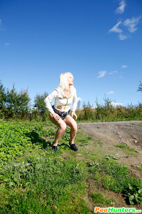 Une jeune femme blonde s'ébroue sur l'accotement d'une route de campagne.
 #78692859