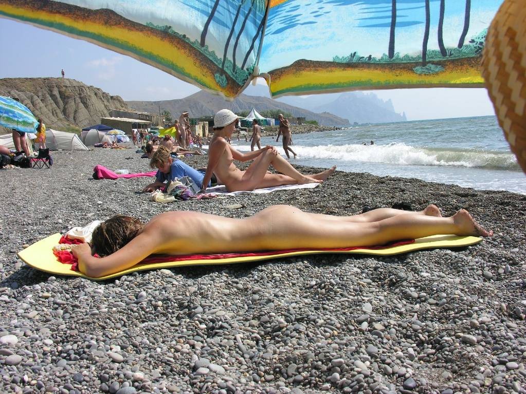 Una coppia di amici giovani nudisti si diverte sulla spiaggia
 #72249996