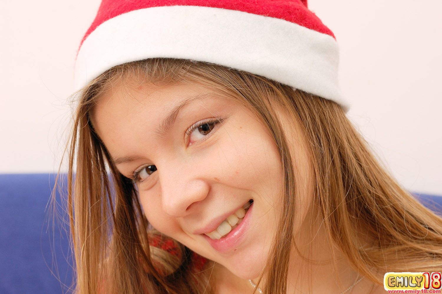 Emily est habillée en rouge comme le Père Noël et elle a des cadeaux.
 #78802340