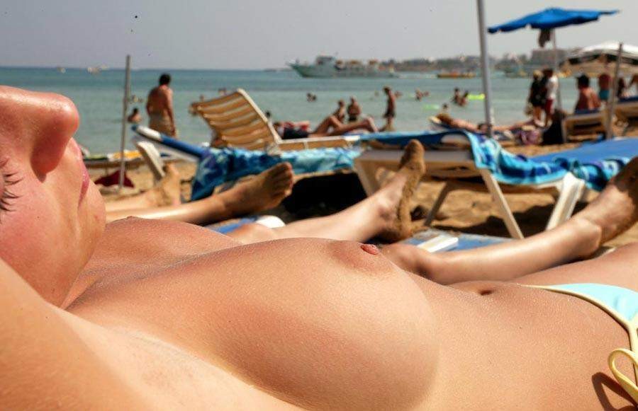 Regardez une nana nue à la plage qui bronze son corps chaud. #72253693