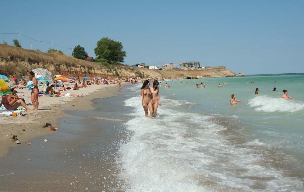 Regardez une nana nue à la plage qui bronze son corps chaud. #72253702