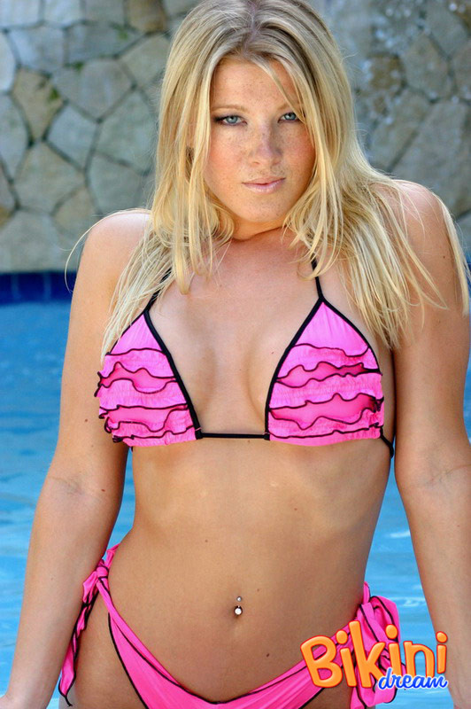 Une blonde en bikini pose au bord de la piscine
 #67849280