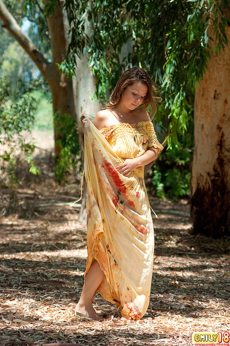 Emily 18 porte une longue et fluide robe hippie en plein air et pose à l'ombre d'un arbre. 
 #67544951