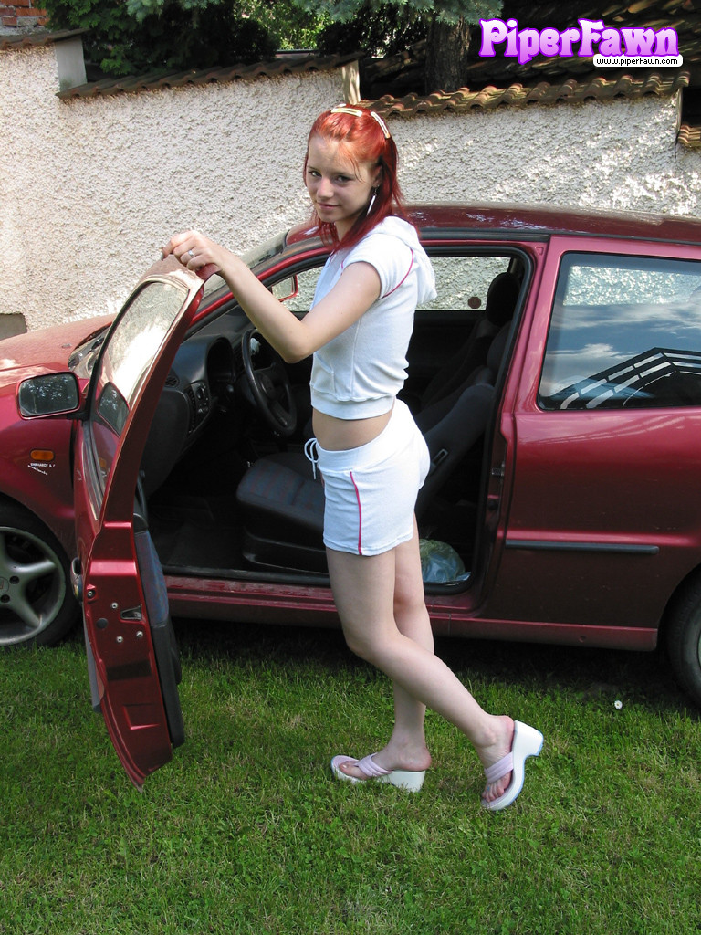 Jeune rousse aux gros seins dehors montrant sa voiture
 #78590664